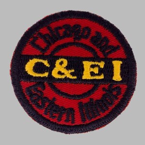 May include: A circular patch with a red background and black border. The text "Chicago and Eastern Illinois" is arched around the top and bottom. The letters "C & EI" are in yellow in the center.