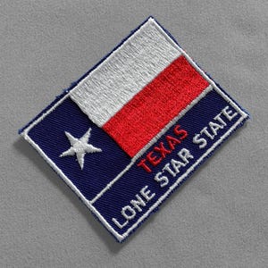 May include: A blue and red embroidered patch with a white star and the text "TEXAS LONE STAR STATE".