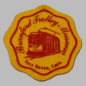 May include: A yellow, scalloped-edge patch with a red border and text. The patch reads "Branford Trolley Museum" with an illustration of a trolley car. The text "East Haven, Conn." is also included.
