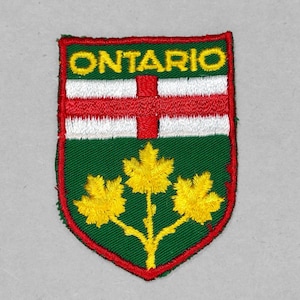 May include: A red, white, and green embroidered patch with the word "ONTARIO" in yellow lettering. The patch features a stylized maple leaf with three leaves.