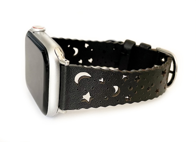 May include: A black leather Apple Watch band with a moon and star cut-out design.