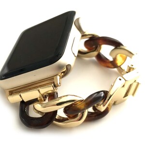 May include: Gold Apple Watch with a brown and gold chain link band.