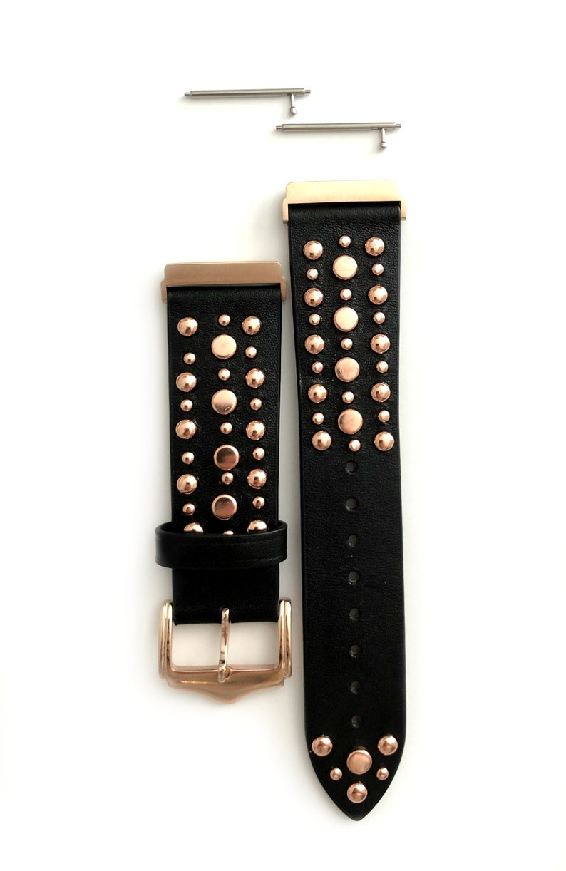 May include: Black leather watch band with rose gold studs and a rose gold buckle. The band is shown with two spring bars.