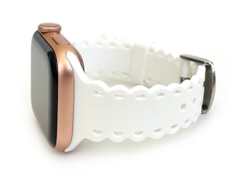 Könnte beinhalten: Weißes Silikonarmband für Apple Watch mit gewelltem Rand und silberner Schließe.