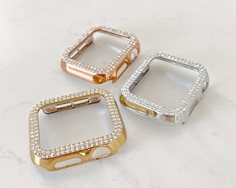 Könnte beinhalten: Drei transparente Schutzhüllen für eine Smartwatch, jede mit einem andersfarbigen Metallrahmen: Gold, Silber und Roségold. Jede Hülle ist mit Strasssteinen besetzt.
