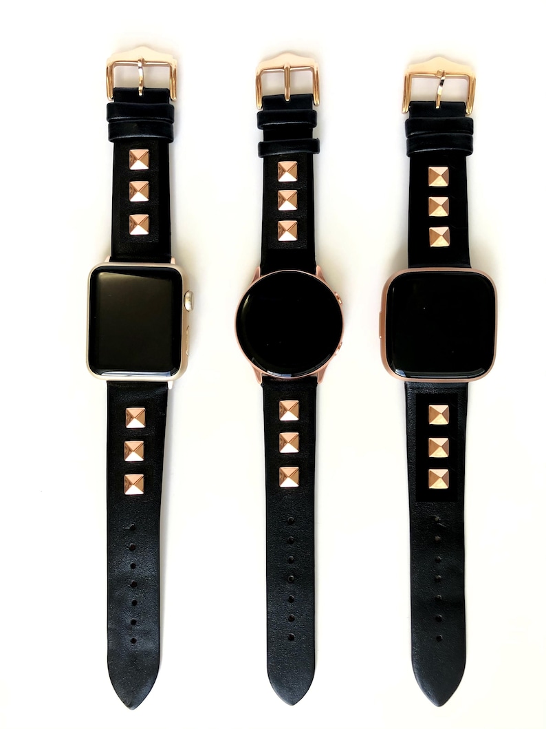 May include: Three black leather watch bands with gold pyramid-shaped studs. The bands are shown on three different smartwatches.