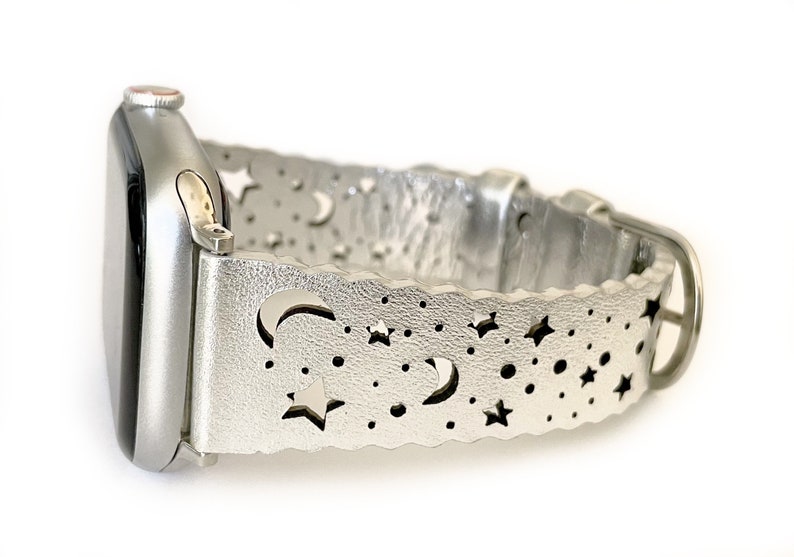 May include: Silver smartwatch band with a moon and stars cut-out design.