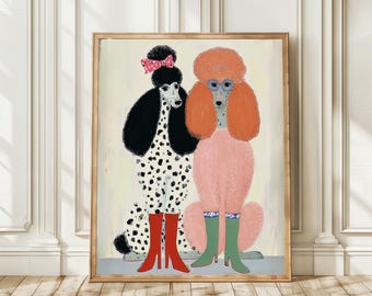 May include: A framed art print featuring two stylized poodles. One is black and white with red boots and a pink bow. The other is pink with orange hair, blue glasses, and green boots. The artwork has a whimsical, illustrative style.