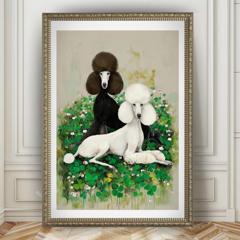 May include: A framed art print featuring two poodles. One poodle is black, the other is white, both with fluffy, stylized fur. They are set against a backdrop of green foliage and white flowers, with a neutral background. The frame is gold.