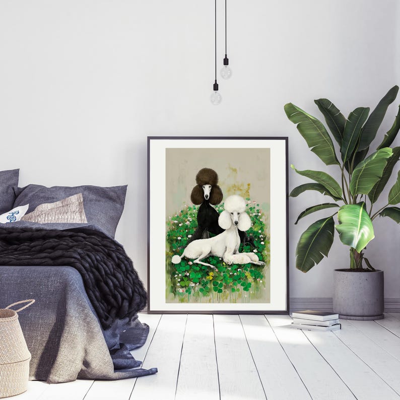 May include: Framed art print featuring two poodles, one black and one white, resting in a bed of green foliage with small white flowers. The poodles are the focal point of the artwork, set against a neutral background.