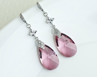 Peut inclure: Une paire de boucles d'oreilles pendantes argentées avec des cristaux roses en forme de larme et de petits cristaux carrés transparents.