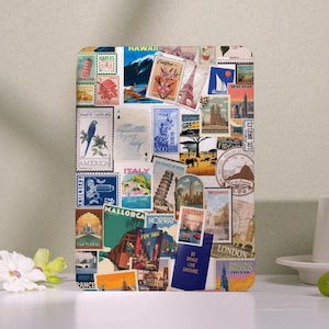 May include: A rectangular travel-themed decorative item covered in vintage postage stamps from various locations, including Hawaii, Italy, and London. The stamps feature landmarks, landscapes, and the text "BE BRAVE LIKE UKRAINE".