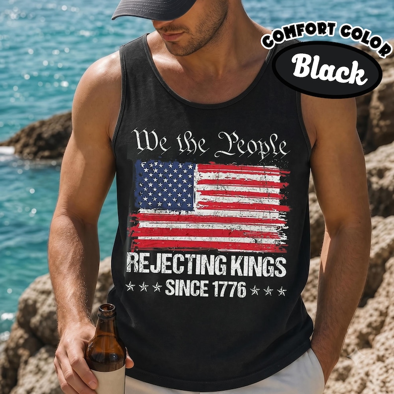 May include: A black tank top featuring a distressed American flag graphic. The text reads We the People above the flag and REJECTING KINGS SINCE 1776 below it, accented by six stars. The design is printed in white, red, and blue on the front.