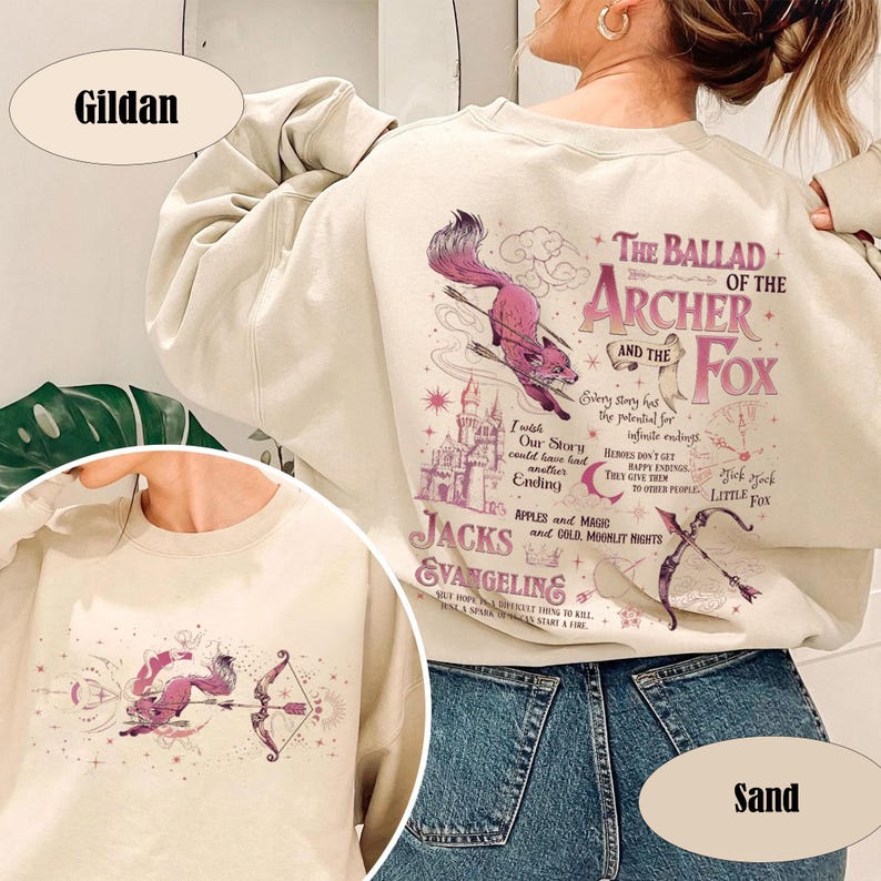 May include: Sand-colored Gildan sweatshirt featuring a graphic design with the text "The Ballad of the Archer and the Fox." The design includes a pink fox with arrows, a castle, and other illustrations.