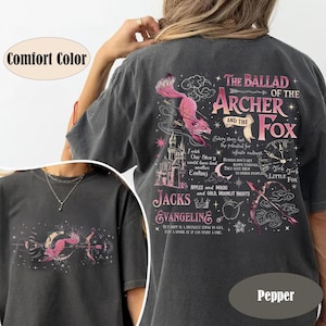May include: Pepper-colored t-shirt featuring a pink fox and text from "The Ballad of the Archer and the Fox." The design includes a castle, bow and arrow, and the words "Jacks" and "Evangeline." The shirt is a Comfort Color.