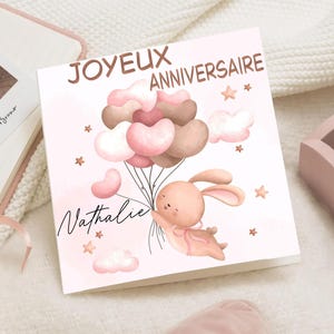 Tarjeta de cumpleaños infantil con globos de conejo volador - Feliz cumpleaños con nombre - Tarjeta de felicitación rosa para bebé - Tarjeta personalizada para el primer cumpleaños