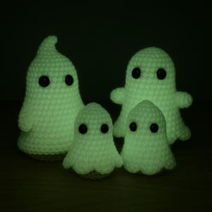 Könnte beinhalten: Vier handgefertigte Häkelgeister in verschiedenen Größen. Die Geister sind weiß mit schwarzen Knopfaugen und leuchten im Dunkeln. Die Häkelgeister sind eine lustige Halloween-Dekoration.