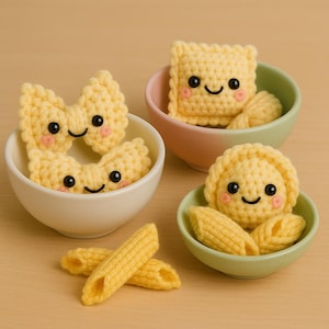 May include: A collection of handmade crochet pasta in small bowls. The pasta includes bow ties, ravioli, and penne, all with smiling faces and blush cheeks. The bowls are in pastel colors, creating a whimsical and playful aesthetic.