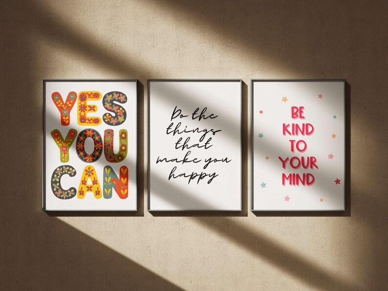 May include: Three framed art prints with inspirational quotes. The first says "YES YOU CAN" in colorful, floral-patterned letters. The second says "Do the things that make you happy." The third says "BE KIND TO YOUR MIND."
