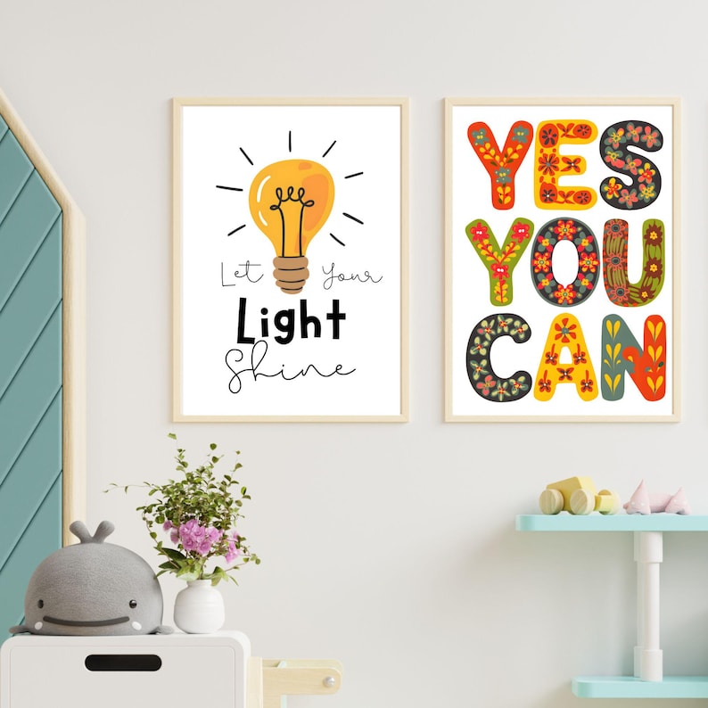 May include: Two framed art prints with inspirational quotes. One features a yellow lightbulb with the text "Let Your Light Shine." The other print says "YES YOU CAN" in colorful, floral-patterned letters. Both are in light wood frames.
