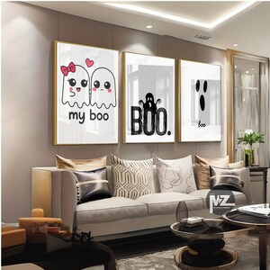 May include: Three framed wall art pieces with gold frames. The art features cartoon ghosts with the phrases "my boo" and "boo." The art is in black and white with a minimalist design, perfect for Halloween decor.