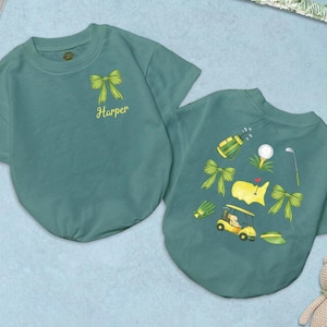 May include: Two teal-colored pet shirts. One shirt features a yellow bow and the name "Harper". The other shirt has a golf-themed design with a golf cart, golf ball, and bows. A teddy bear is in the bottom right corner.