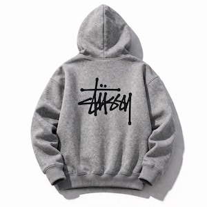 May include: A gray hoodie with a drawstring hood and a large black logo on the back. The logo is a stylized wordmark. The hoodie is made of a soft, comfortable material, perfect for casual wear. The hoodie is a classic streetwear staple.