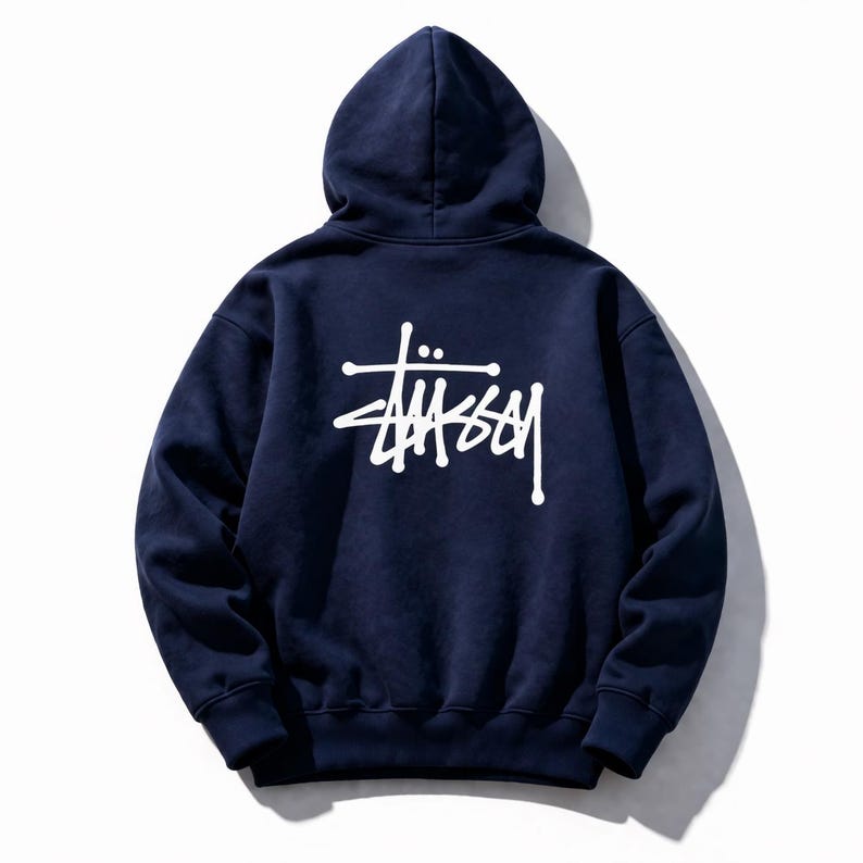 May include: Navy blue hooded sweatshirt with a white logo on the back. The sweatshirt has a drawstring hood and a kangaroo pocket. The logo is a stylized signature in a bold, sans-serif font. The garment is made of a soft, comfortable material.