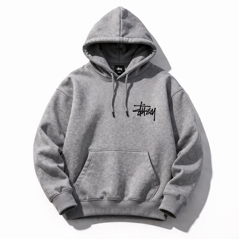 May include: A gray hooded sweatshirt with a front pocket and drawstring. The black logo "St&uuml;ssy" is printed on the front. The sweatshirt is made of a soft material and is suitable for casual wear.