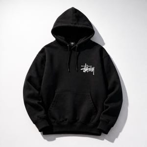 May include: Black hooded sweatshirt with a kangaroo pocket and drawstring. The white logo of the brand is printed on the front. The sweatshirt is made of a soft, comfortable material.