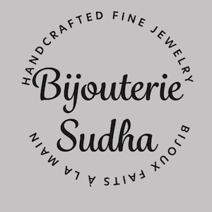 Puede incluir: Un logotipo circular sobre un fondo gris claro con el texto negro Bijouterie Sudha en el centro. Las palabras Handcrafted Fine Jewelry est&aacute;n arqueadas en la parte superior, y las palabras Bijoux Faits &agrave; la Main est&aacute;n arqueadas abajo.
