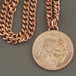 Solid copper necklace with a copper buffalo pendant. The chain is a cuban link style. The pendant features a detailed profile of a Native American with the word LIBERTY visible.  The necklace is a stylish and unique piece of jewelry.