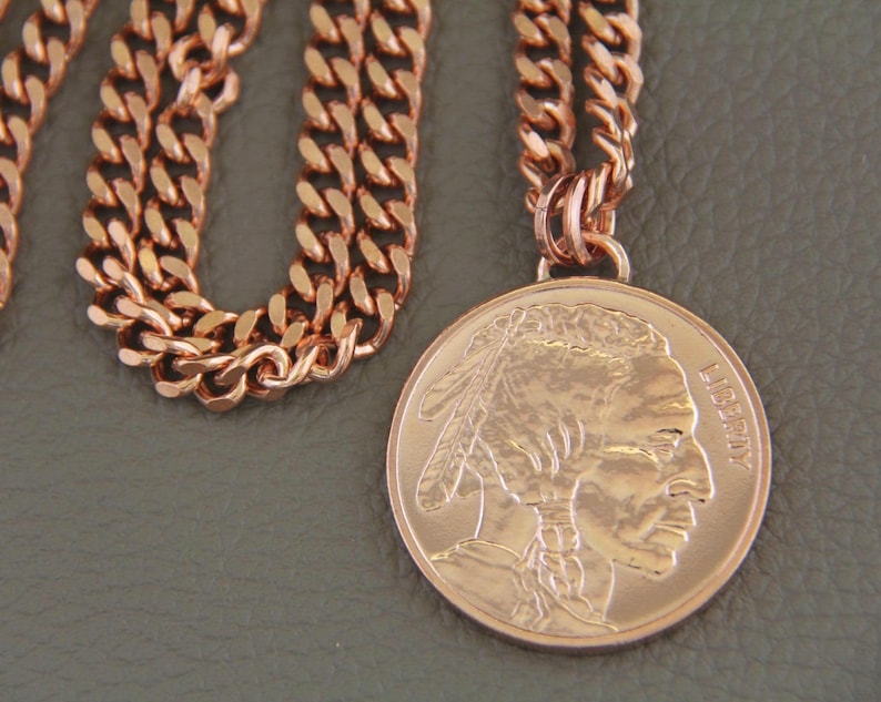Solid copper necklace with a copper buffalo pendant. The chain is a cuban link style. The pendant features a detailed profile of a Native American with the word LIBERTY visible.  The necklace is a stylish and unique piece of jewelry.