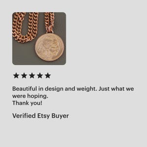 May include: A copper-toned necklace with a large, circular pendant displaying a detailed profile. The necklace has a chunky chain. The image also includes text that reads: "Beautiful in design and weight. Just what we were hoping. Thank you! Verified Etsy Buyer."