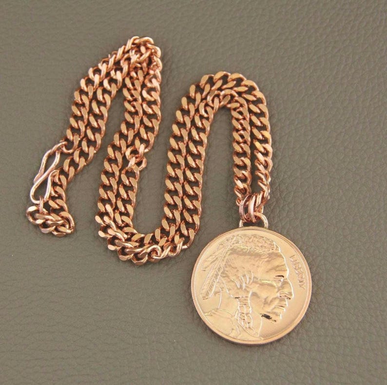 Solid copper necklace with a copper buffalo pendant. The chain is a cuban link style. The pendant features a detailed profile of a Native American with the word LIBERTY visible.  The necklace is a stylish and unique piece of jewelry.
