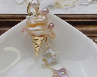 May include: An unusual earring with a gold-coloured ice cream cone design, a pearl scoop, and star-shaped pearl dangles. The earring has a gold hoop and several pearls. The text "TINA PEARL" is at the top.