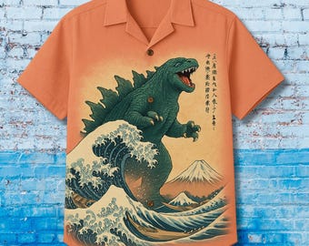 May include: Orange short-sleeved button-down shirt featuring a Godzilla graphic in the style of a Japanese woodblock print. The design includes a green Godzilla, a large wave, and a mountain. The shirt has a classic collar and a single button.