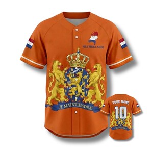 May include: Orange baseball jersey with white and orange striped sleeves. Features the Netherlands coat of arms, the text "NETHERLANDS", and the phrase "JE MAINTIENDRAI". A smaller jersey with "YOUR NAME" and the number 10 is also visible.