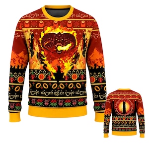 May include: A long-sleeve crewneck sweatshirt featuring a vibrant red, orange, and black pattern. The front displays a fiery creature with horns, a silhouette of a figure holding a staff, and bands of text in a script font. The back shows a dark tower.