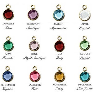 May include: Twelve small gemstone charms, each representing a different month of the year. The charms are gold-colored with a variety of colored gemstones, including red, blue, green, purple, and clear.