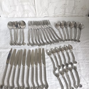 Vintage vridna gafflar, skedar eller knivar, spiralformad snigeldesign, urval av antika medeltida smidda bestick, virvelbestickset