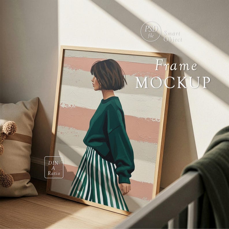 Op de afbeelding: Een ingelijste kunstdruk met een vrouw in een groene trui en een gestreepte rok. Het kunstwerk heeft een licht houten frame en leunt tegen een muur. De achtergrond heeft roze en witte strepen. De woorden "Frame MOCKUP" zijn zichtbaar.