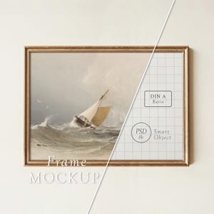 May include: A framed vintage painting of a sailing boat in stormy waters. The artwork is in a gold-coloured frame and shows a ship struggling against waves. The words "Frame Mockup" are at the bottom.