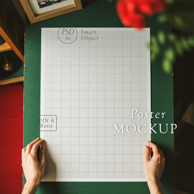 K&ouml;nnte beinhalten: Ein wei&szlig;er Poster-Mockup mit einem Rastermuster, beschriftet mit "DIN A Ratio" und "Poster MOCKUP". Das Poster wird von H&auml;nden auf einer gr&uuml;nen Oberfl&auml;che gehalten.
