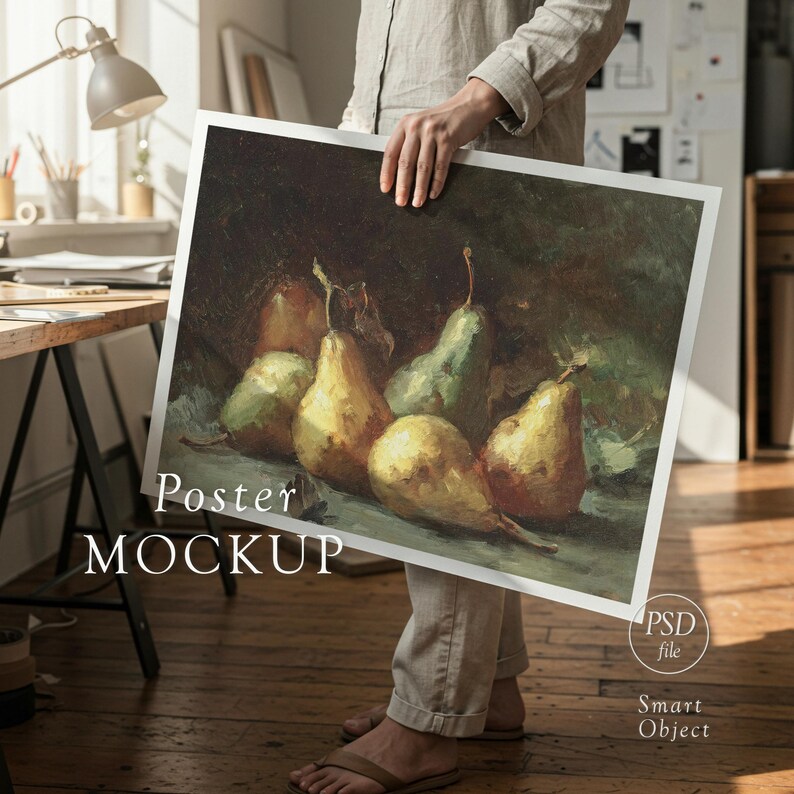 May include: A person holding a poster mockup featuring a still life painting of pears. The pears are yellow and green, with brown stems and leaves. The poster has the words "Poster MOCKUP" printed on it.