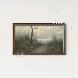 May include: A framed landscape painting with a dark wooden frame. The artwork depicts a path leading through a misty, wooded area with bare trees and flying birds. The text "Frame Mockup" is overlaid on the image.