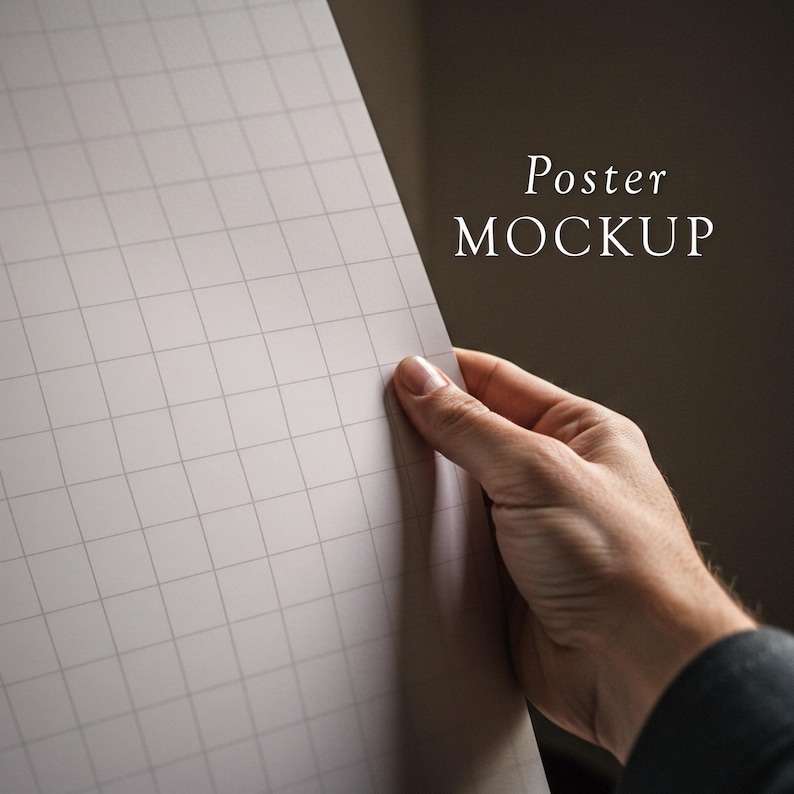 May include: A hand holds up a blank white poster with a grid pattern. The poster is titled "Poster MOCKUP".