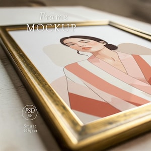 May include: A gold-framed art print featuring a woman in a striped robe. The artwork has a neutral color palette with shades of peach, beige, and white. The words "Frame Mockup" are displayed at the top, and "PSD file" and "Smart Object" are at the bottom.