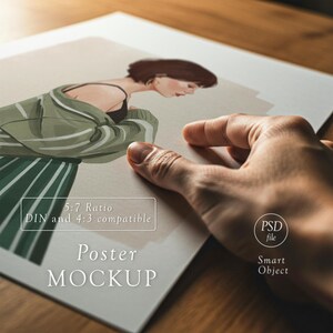 Pode incluir: Uma maquete de cartaz com uma ilustra&ccedil;&atilde;o de uma pessoa com um casaco verde e uma saia listrada. O cartaz inclui o texto "Poster MOCKUP", "5:7 Ratio", "DIN and 4:3 compatible" e "Smart Object". Uma m&atilde;o segura o cartaz.