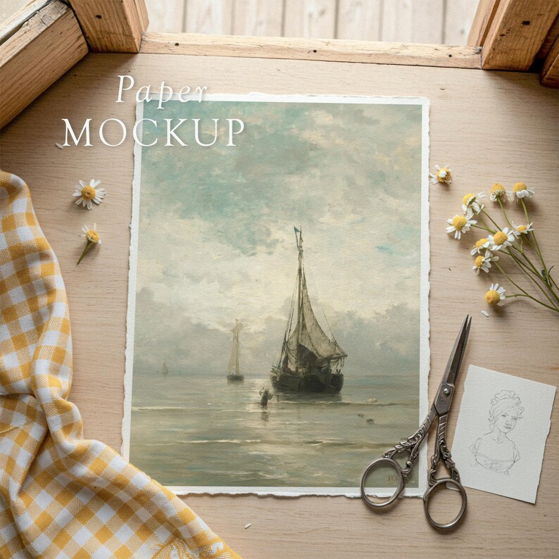 May include: A paper mockup featuring a vintage seascape painting with sailboats. The scene is set on a wooden surface, with scissors, a sketch, and daisies. The text "Paper MOCKUP" is visible.